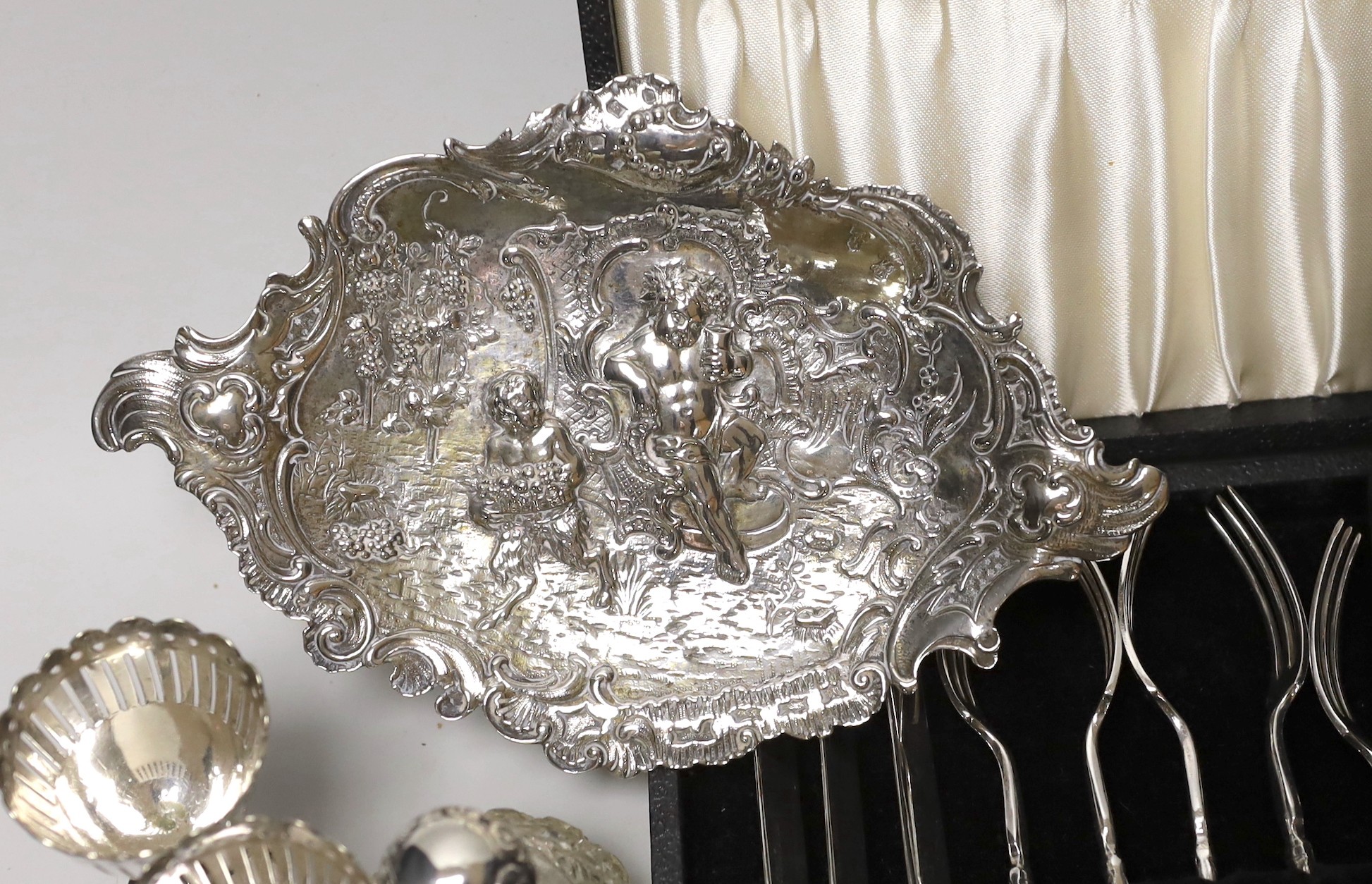 Sundry small silverwares including flatware, a pair of mounted glass scent bottles, a white metal German dish and minor plated items.